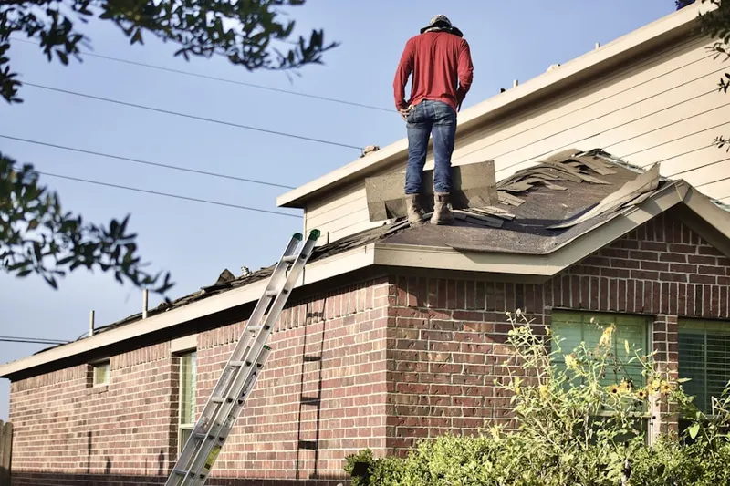 Professional roofer working on a residential roof in Woods Tavern